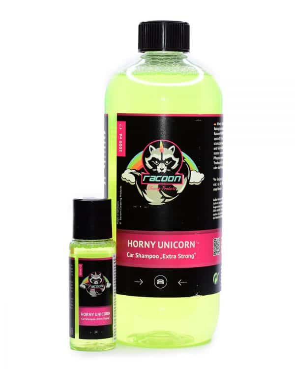 dve priehľadné fľaše rôznej veľkosti, obsahujúce silný autošampón Horny Unicorn sýtej zelenej farby pre exteriér vozidla, s výrazným logom Racoon Cleaning Products