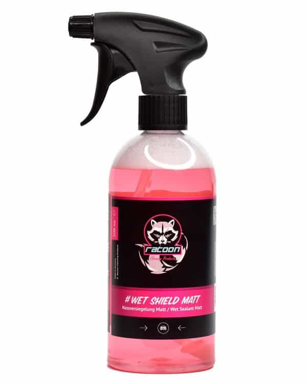 priehľadná fľaša s rozprašovačom obsahujúca ružovo číru tekutinu, prípravok určený ako tekutý vosk pri umývaní automobilov s matným lakom alebo fóliou Wet Shield Matt, s etiketou a logom autokozmetiky Racoon Cleaning Products