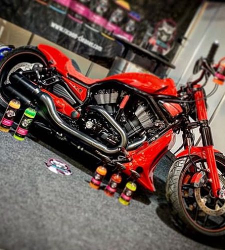 motocikel Harley Davidson červenej farby a produkty Racoon Cleaning Products